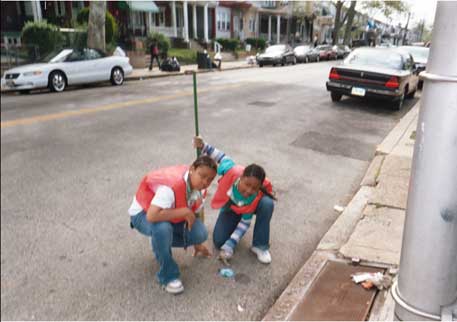 Two youth participating in the weekend storm drainage clearing activity.